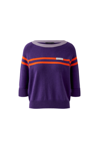 A purple knit sweater with three-quarter sleeves, featuring two horizontal orange stripes across the chest and shoulders, a light gray ribbed crew neck, and a small white brand label on the chest.
