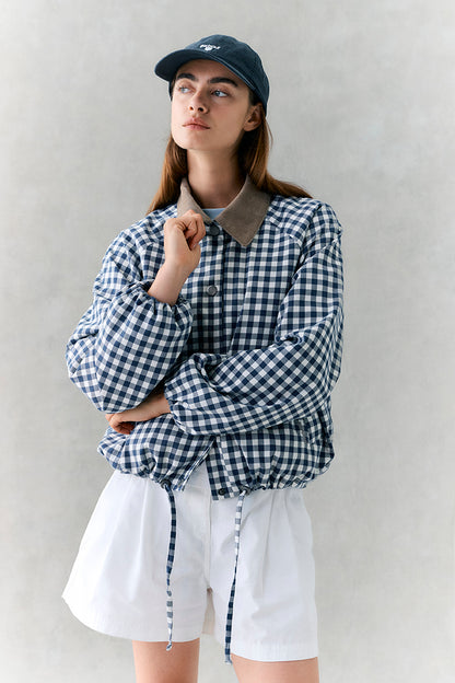 Person wearing a black and white checkered shirt with a plain background