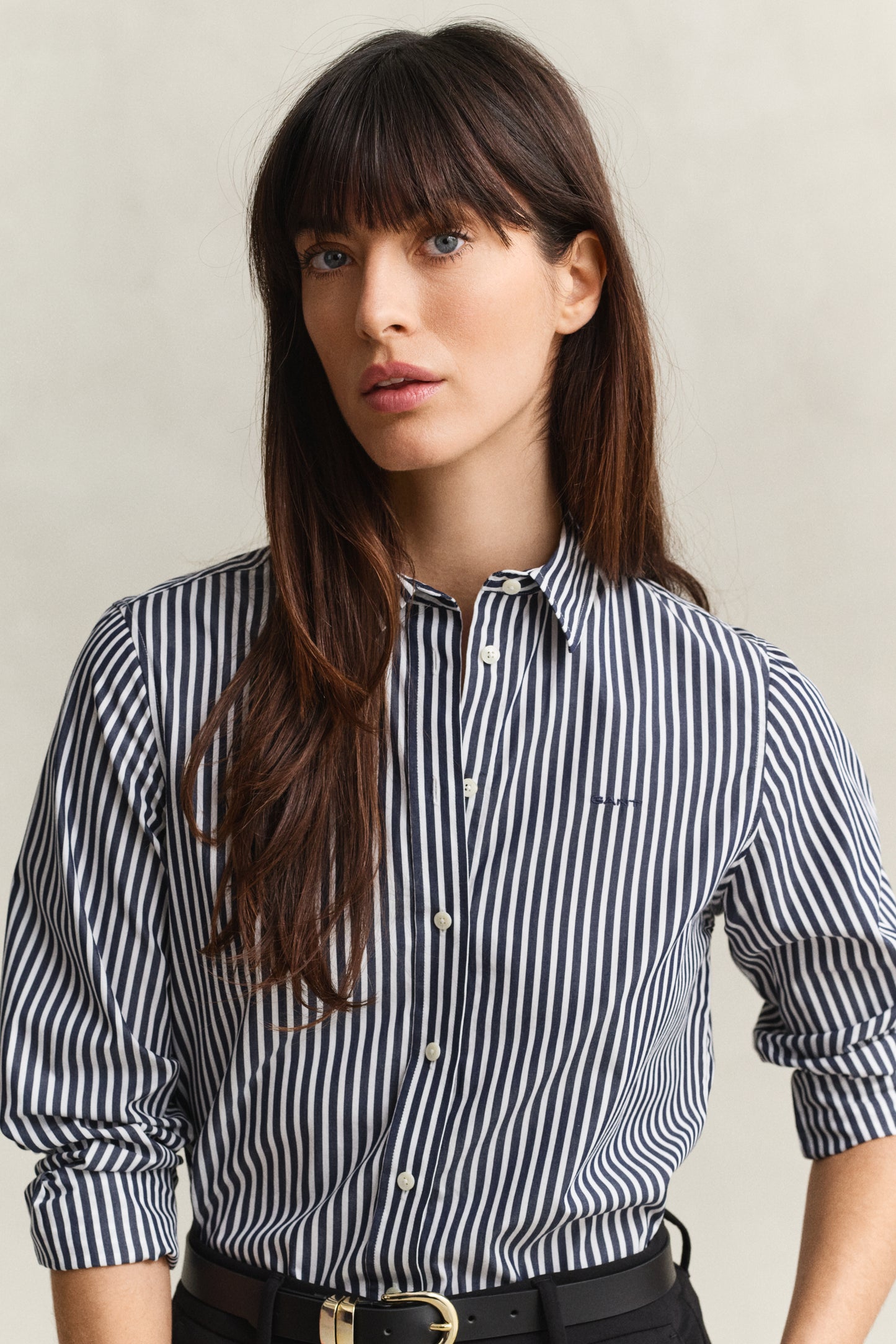 Woman wearing a black and white striped shirt against a neutral background
