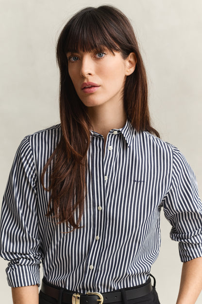 Woman wearing a black and white striped shirt against a neutral background