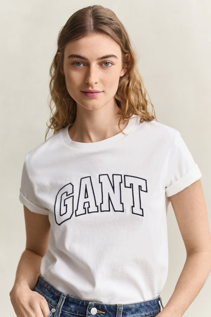 Woman wearing a white t-shirt with 'GANT' logo against a plain background