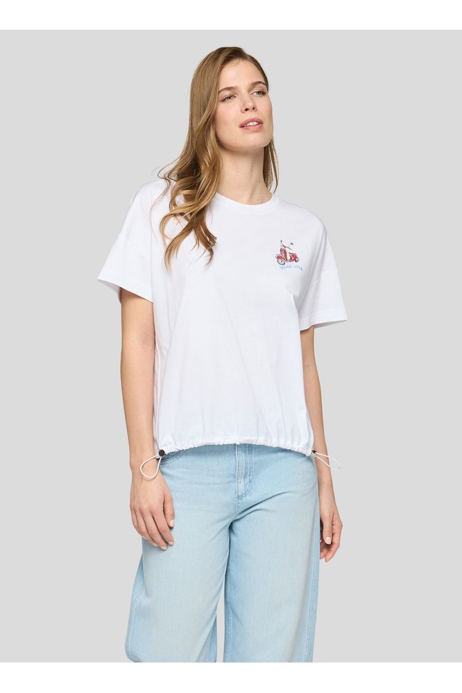 Woman wearing a white t-shirt with a small logo on a light gray background