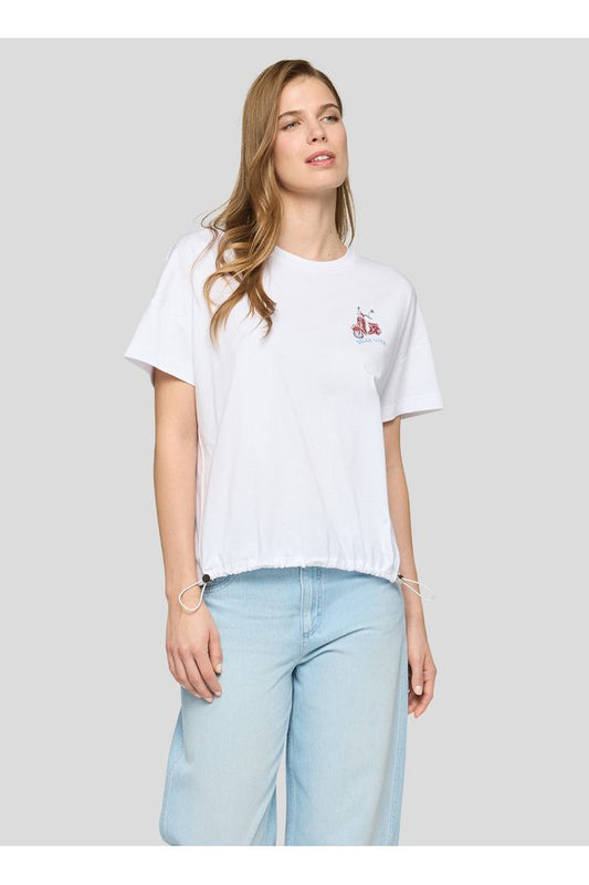 Woman wearing a white t-shirt with a small logo on a light gray background