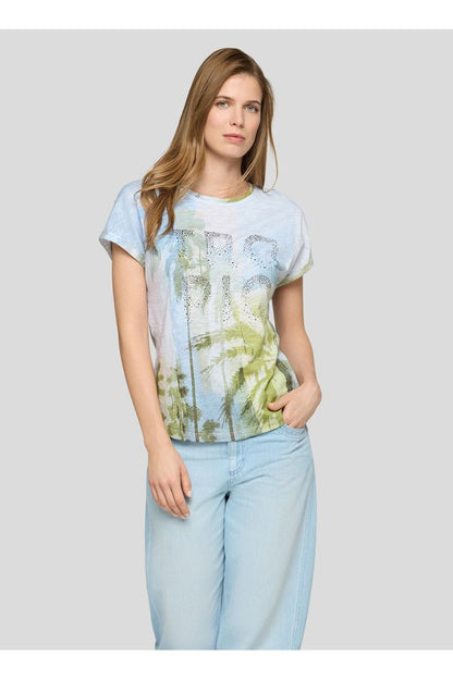 Woman wearing a light blue t-shirt with a palm tree design and light blue jeans on a white background