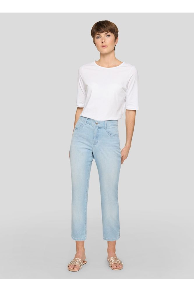 Woman wearing a white top and light blue jeans on a gray background