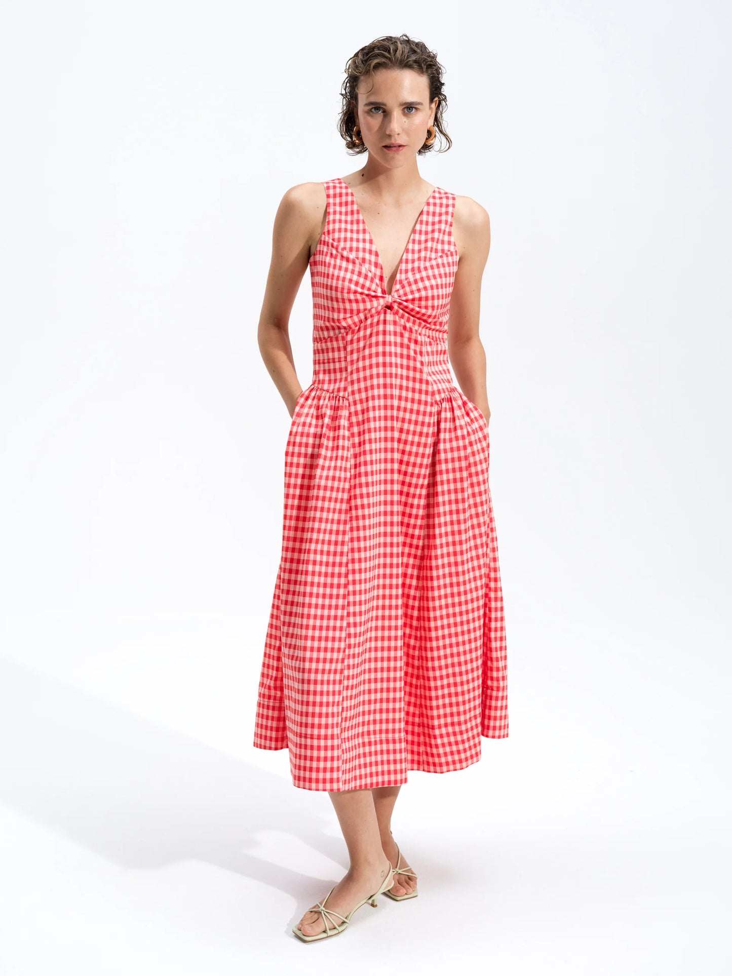 Woman wearing a red and white checkered dress on a white background